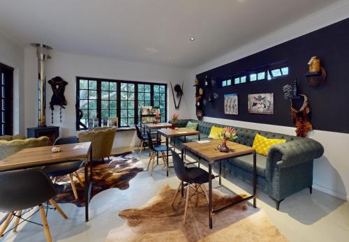 a living room with a couch and tables and chairs at Africa Lodge in Somerset West