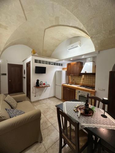 a kitchen and a living room with a table and a couch at Princess Mafalda house in Grottaglie