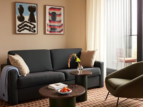 a living room with a blue couch and a table at Numa Amsterdam Vondelpark in Amsterdam