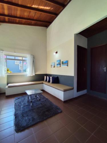 a living room with a bench and a window at Pousada do Betão in Guarda do Embaú