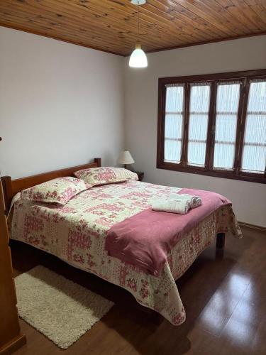 a bedroom with a bed in a room with windows at Recanto da Vovó in Campos do Jordão