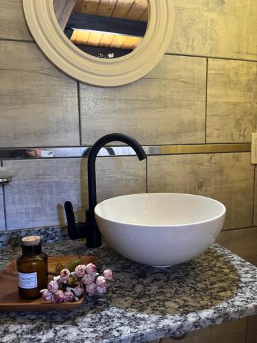 bagno con lavabo bianco e specchio di Aire Escondido a Villa Berna