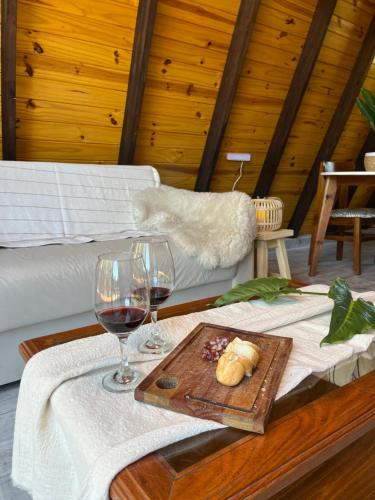 un tavolo con due bicchieri di vino e un vassoio di cibo di Aire Escondido a Villa Berna