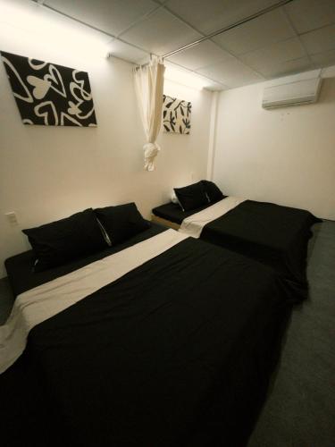 two beds in a room with black and white at TM Homestay Trung Tâm Phan Thiết 2 in Phan Thiet