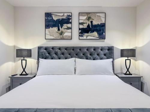 een slaapkamer met een groot wit bed met twee lampen bij Westland Lodge in Brookmans Park