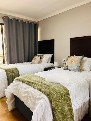 a bedroom with three beds with white blankets and pillows at The Duckpond Inn in Fraser