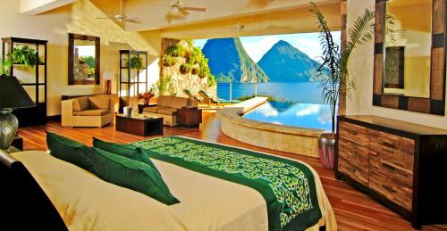 a bedroom with a large bed and a bath tub at Jade Mountain in Soufrière