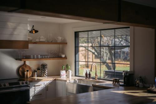 a kitchen with a sink and a large window at The County Haus - Indoor Pool & Finnish Sauna in West Lake