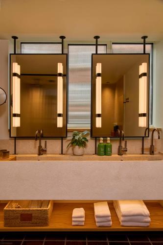 a bathroom with two sinks and a large mirror at 1 Hotel Copenhagen in Copenhagen
