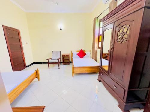 a room with a bedroom with a bed and a chair at Vuga Hostel in Zanzibar City