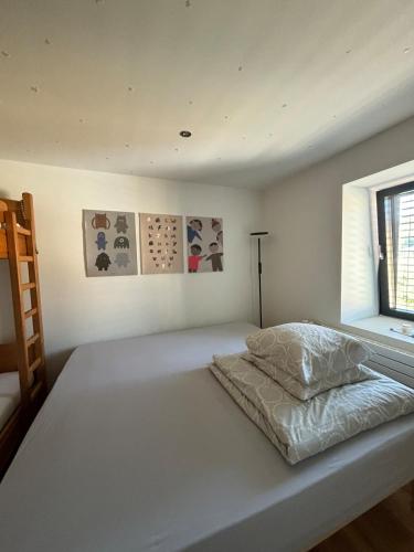 a white bed in a room with a window at Spacious house next Kirchberg-Centre with parking in Luxembourg