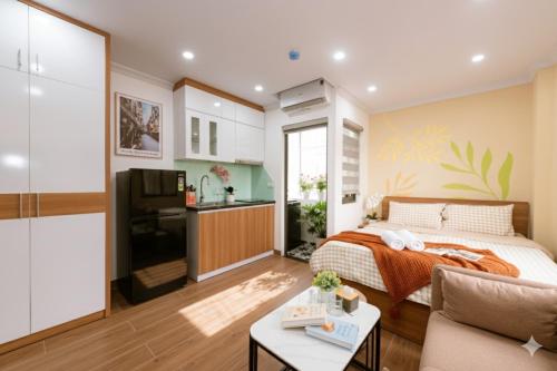 a bedroom with a bed and a kitchen at Aurelia Aparthotel Hanoi in Hanoi