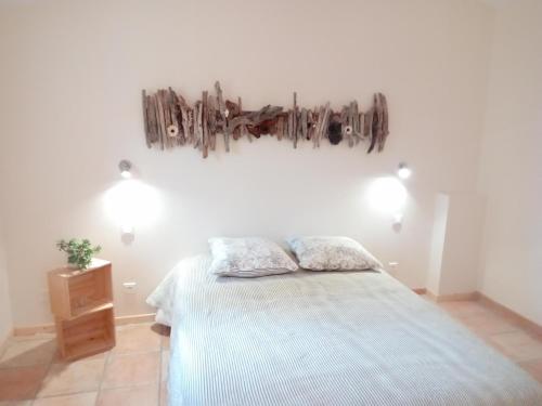 ein Schlafzimmer mit einem Bett und zwei Kissen darauf in der Unterkunft Maisonnette avec terrasse in Gréoux-les-Bains