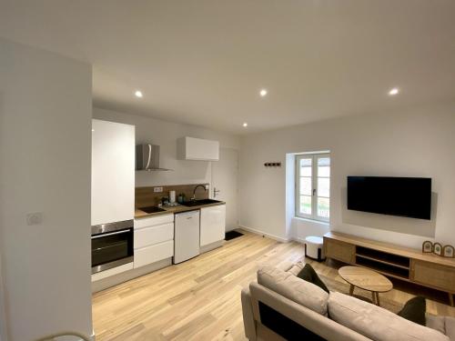 a living room with a couch and a kitchen at Au Passage de Pommard in Pommard