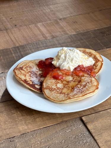 two pancakes with jam and butter on a white plate at Norrfly Herrgård in Kilafors