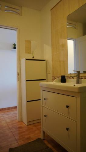 eine Küche mit einer Spüle, einem Spiegel und einem Kühlschrank in der Unterkunft Apartamento con vista frontal al mar in El Médano