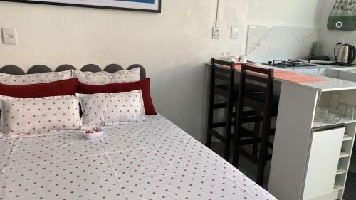 ein Schlafzimmer mit einem Bett mit gepunkteten Kissen in der Unterkunft Studio Beira Mar in Imbituba