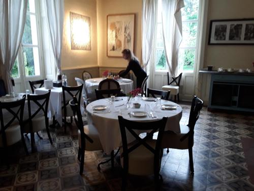 een vrouw die aan een tafel in een restaurant zit bij Château de Prety - Maison d'Hôtes in Préty