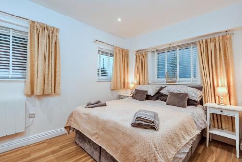 Finest Retreats - North View Annexe في Gilsland: غرفة نوم بها سرير ونافذتين