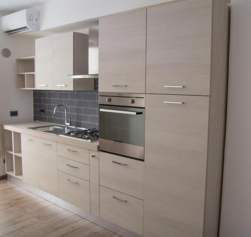 a kitchen with white cabinets and a stove at Enjoy Home in Acitrezza