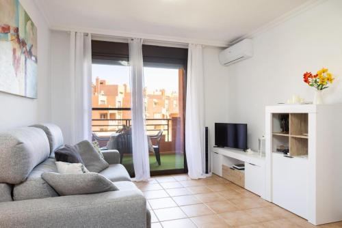 Una sala de estar con un sofá y un televisor. en Apartamento Sotavento III S, en La Tejita