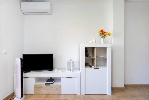 Una sala de estar con un escritorio blanco con un televisor. en Apartamento Sotavento III S, en La Tejita