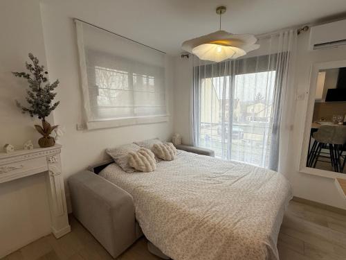 a bedroom with a bed and a large window at Le Ptit Cocon Disneyland 10 min in Coupvray