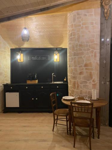une salle à manger avec une table et des chaises et un mur en pierre dans l'établissement La Belle Vie La, à Saintry-sur-Seine
