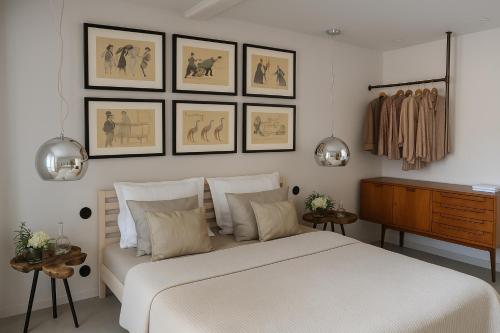 a bedroom with a white bed and some pictures on the wall at Campo de Santa Clara 98 in Lisbon