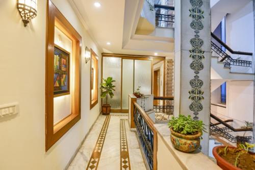 a hallway with stairs and potted plants in a building at FabHotel Siris 18 - Aravali Biodiversity Park in Gurgaon