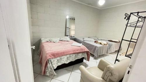 Casa aconchegante في Jandira: غرفة مستشفى بسريرين ومرآة