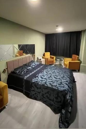 a bedroom with a large bed and some chairs at Ozan suit in Bursa