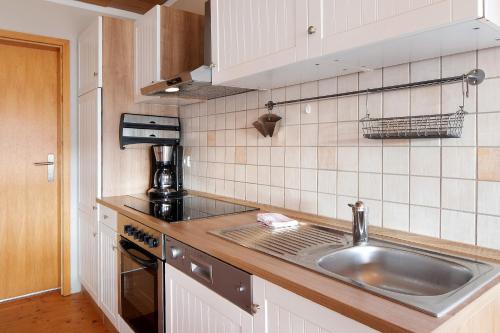 Haus Wintersonne في Falkau: مطبخ مع حوض وطاولة عمل