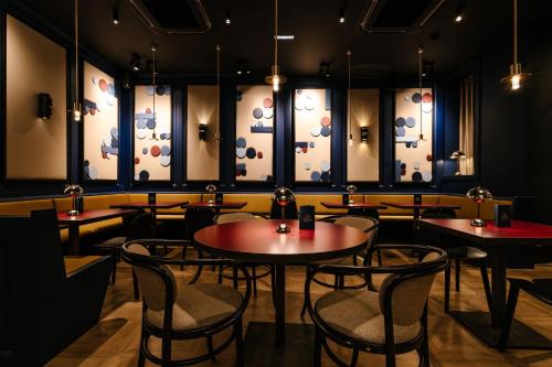 a restaurant with tables and chairs in a room at HANNONG Hotel & Wine Bar in Strasbourg