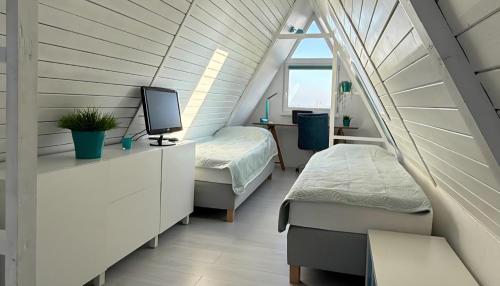 a room with two beds and a tv in a attic at Villa Aurora in Waldbrunn