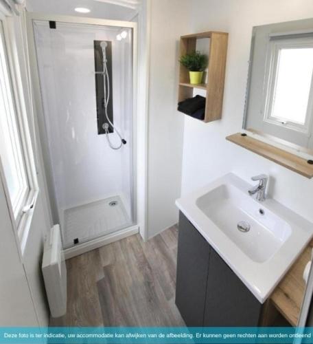 a white bathroom with a sink and a shower at Siblu Camping in de Bongerd in Oostkapelle