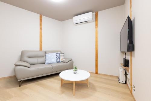a living room with a couch and a table at YUKIMARU in 2 in Tokyo