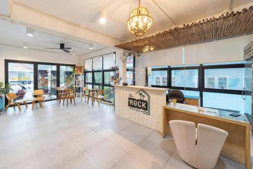 a lobby of a hotel with tables and chairs at The Rock Samui Poshtel Lamai Beach in Lamai