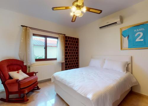 une chambre avec un lit et une chaise rouge dans l'établissement Villa Tranquillity, à Kharcha