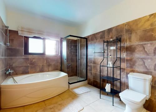 une salle de bain avec baignoire et toilettes dans l'établissement Villa Tranquillity, à Kharcha