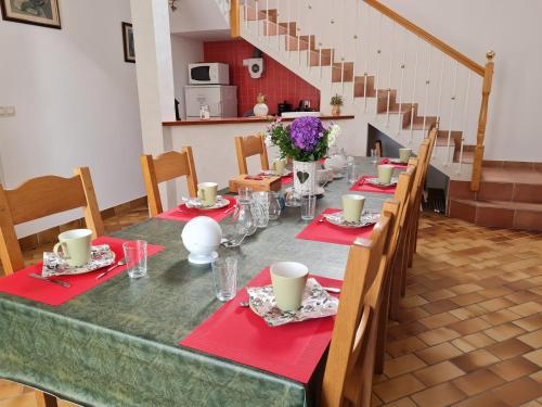 a long table with red napkins and flowers on it at Chambre 1, Les Lilas in Cravant
