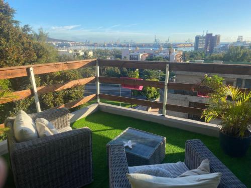 Un patio con sillas y una mesa en un balcón. en Casa Doramas VV, en Las Palmas de Gran Canaria