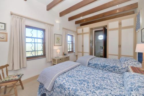 een slaapkamer met twee bedden, een tafel en een raam bij Blombossie in Arniston