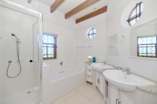 een witte badkamer met twee wastafels en een douche bij Blombossie in Arniston