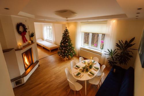 a living room with a christmas tree and a table and chairs at Cozy Garden Villa in Ventspils