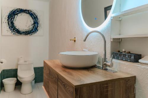 a bathroom with a bowl sink on a wooden counter at Gaestehaus ESSENCE 