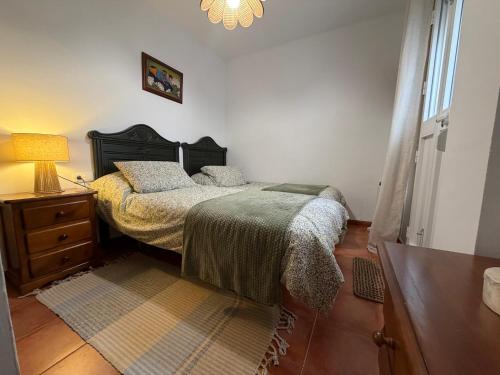 una camera con letto, cassettiera e lampada di Casa Rural Grazalema a Grazalema