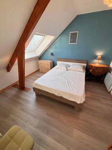 ein Schlafzimmer mit einem Bett und einer blauen Wand in der Unterkunft Ti Laja - nuage de coton 30m plage in La Baule-les-Pins