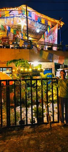 Peace and love beach stay في أليبي: رجل يقف بجوار سياج في الليل