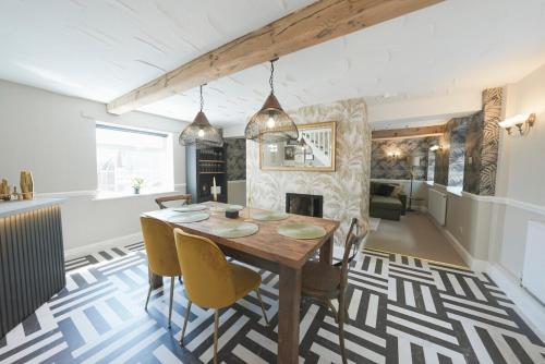 Un comedor con mesa y sillas y chimenea. en The Machine House - Hot Tub - Outdoor Bar, en Ashby de la Zouch